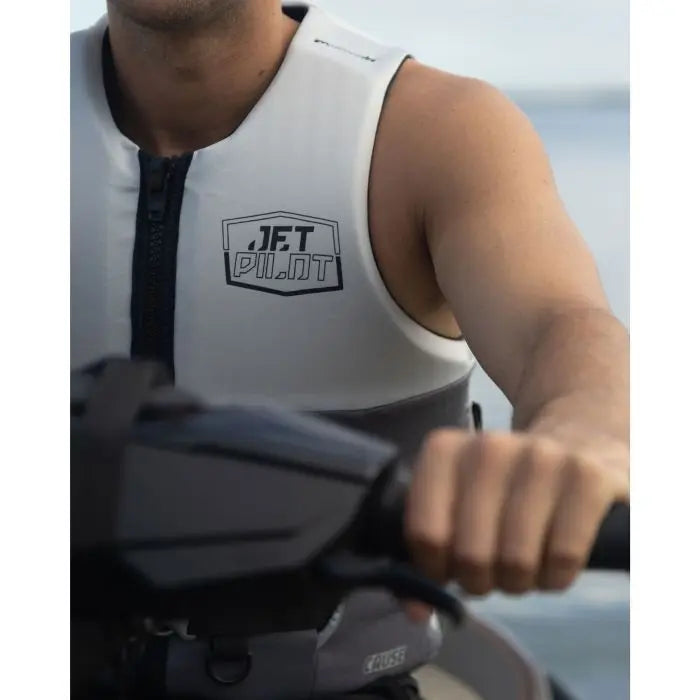 Person wearing a white sleeveless shirt with a logo, holding onto a handle.